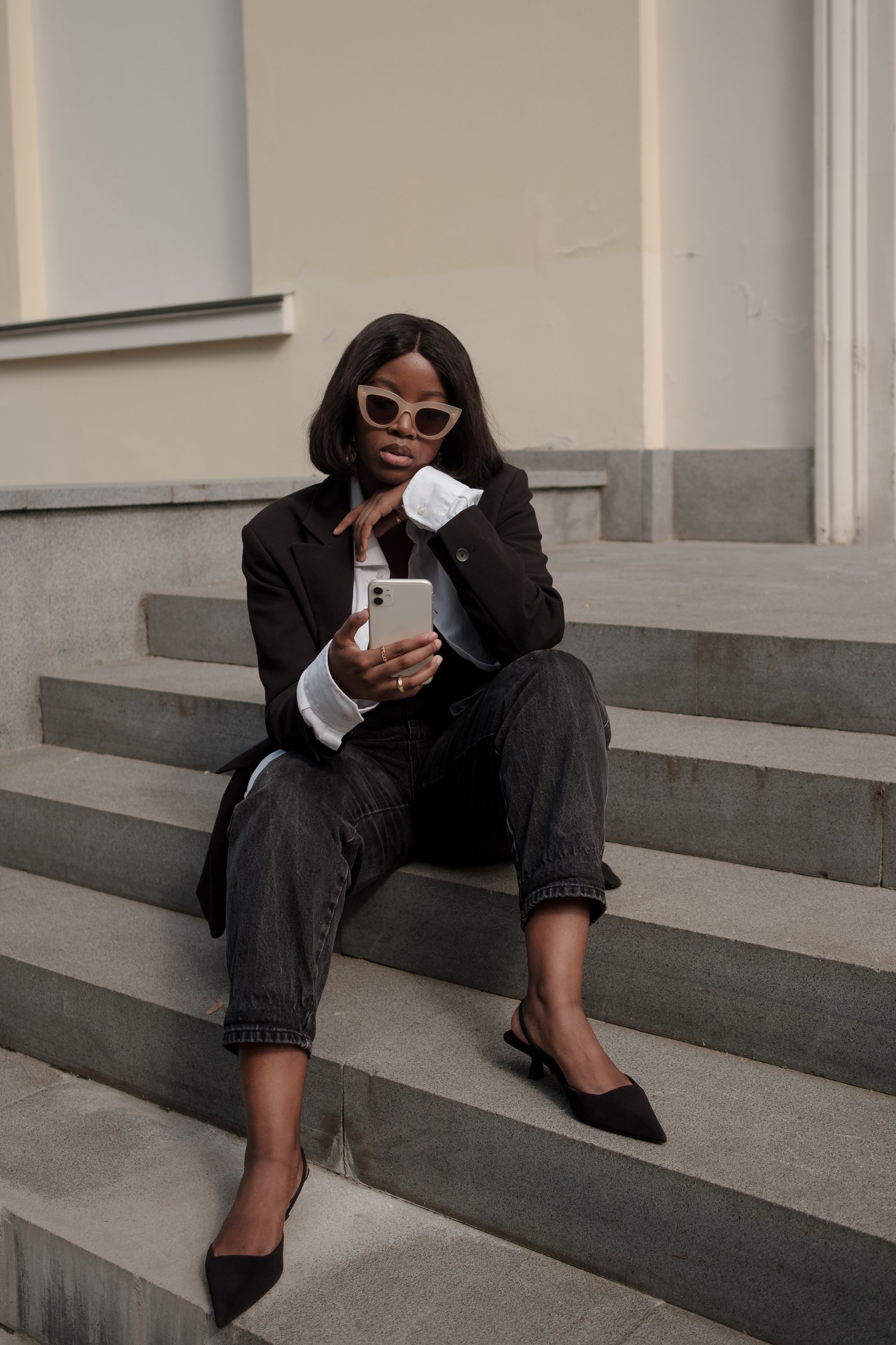 Woman in Black Outfit on Stairs While Using Smartphone