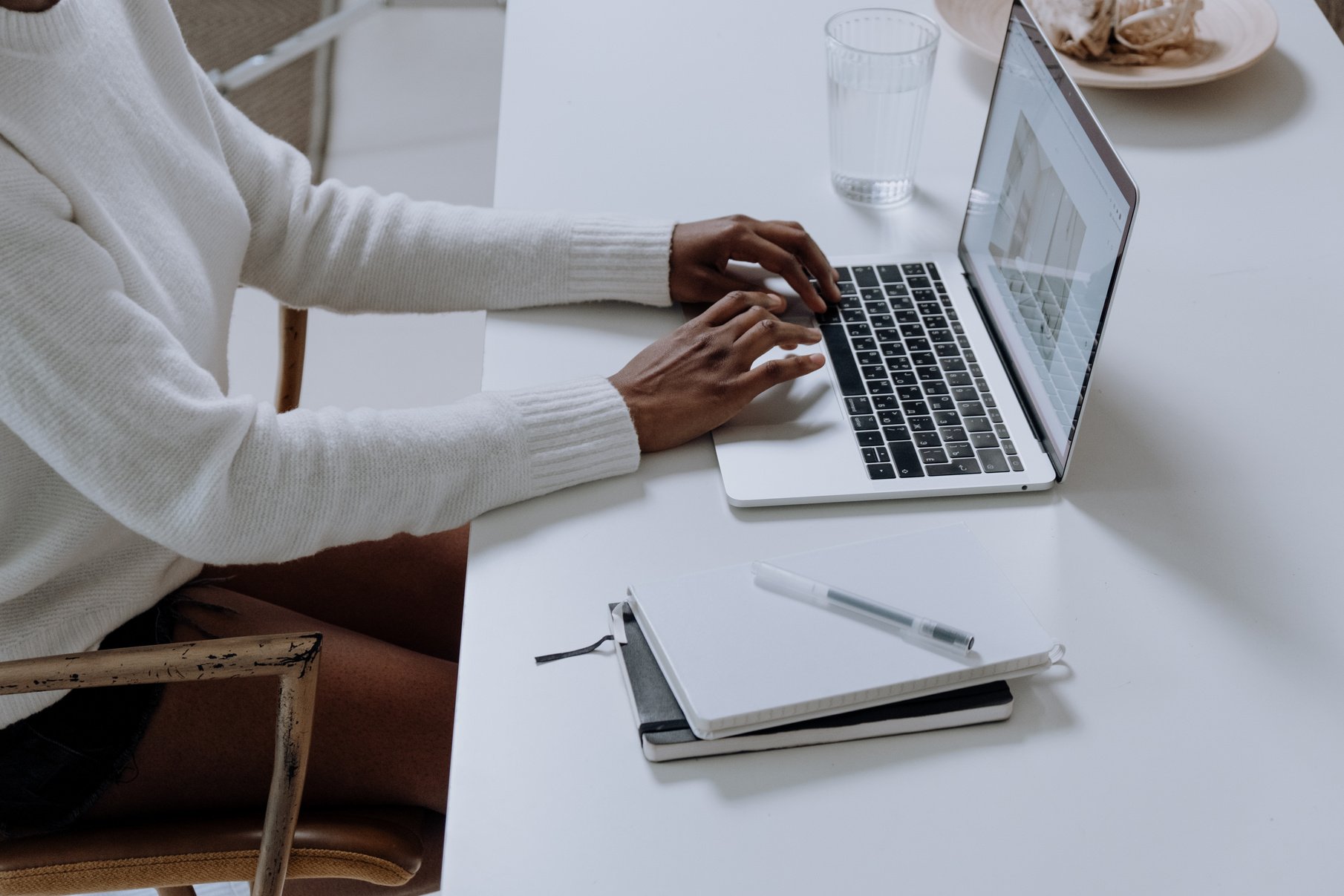 Person in White Long Sleeve Shirt Using Macbook Pro